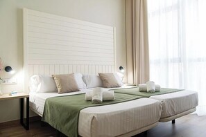 A hotel room with a large bed, two bedside tables, and a view of the outdoors. - Lindon Boutique Hotel (Bakı)