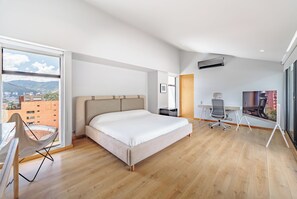Ein modernes Hotelzimmer mit einem großen Bett, einem Schreibtisch und einem Stuhl.
