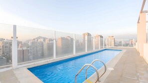 A rooftop swimming pool with a city view, surrounded by a glass barrier. - Torre San Isidro by Domus Travels (Santiago)