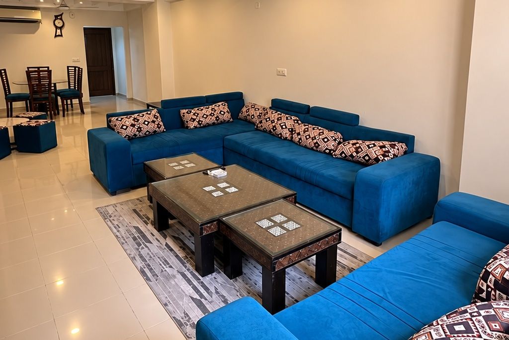 A living room with a sectional sofa, two coffee tables, and a dining area with chairs and a table.
