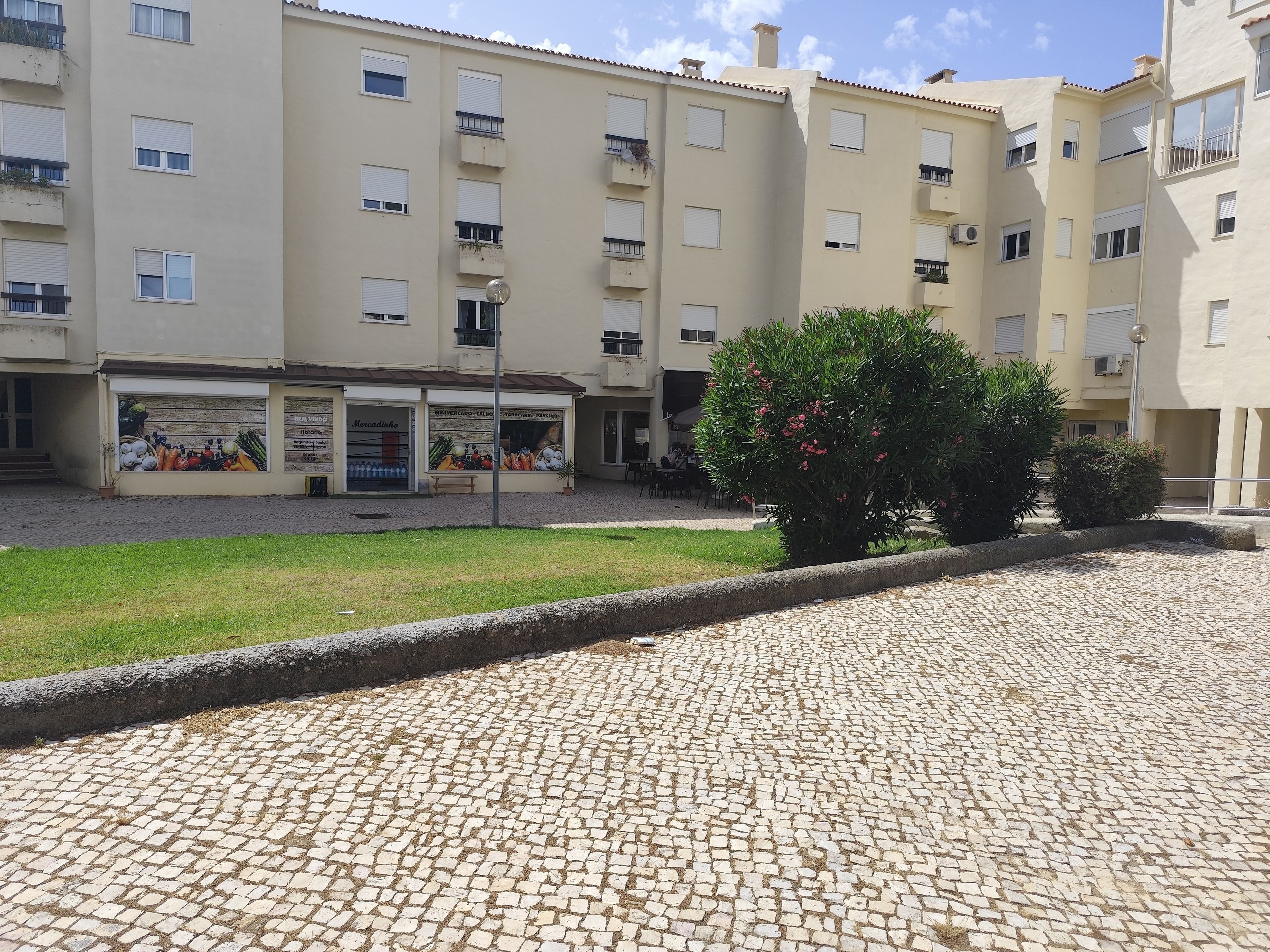 A courtyard with a cobblestone floor, surrounded by multi-story buildings with balconies and windows.