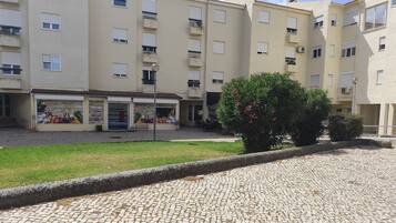 A courtyard with a cobblestone floor, surrounded by multi-story buildings with balconies and windows.