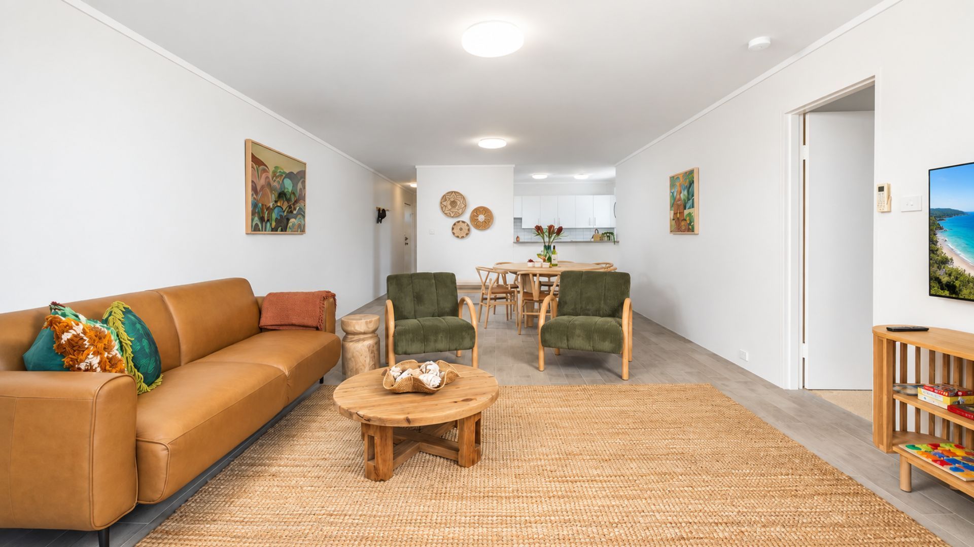 Una sala de estar con sofá, sillas, una mesa de centro y una zona de comedor con mesa y sillas.