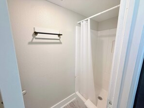 Une salle de bain avec une douche, un porte-serviettes et des toilettes.