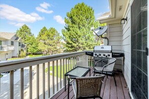 A balcony with a grill, wicker chairs, and a view of a residential area. - Sunny 2BR | Pool and Parks | Central Local (Lafayette)