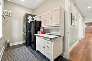 A compact kitchen with a refrigerator, a sink, and cabinets.