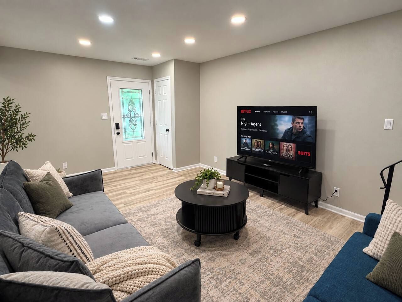 Ein Wohnzimmer mit einer Couch, einem Couchtisch und einem Flachbildfernseher, der eine Fernsehsendung zeigt.