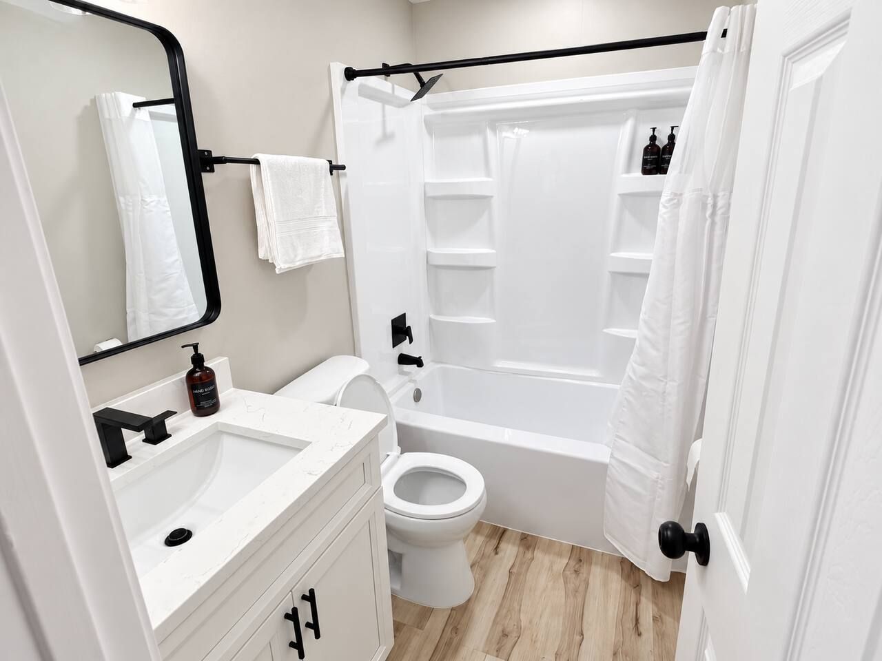 A modern bathroom with a white sink, toilet, and bathtub.