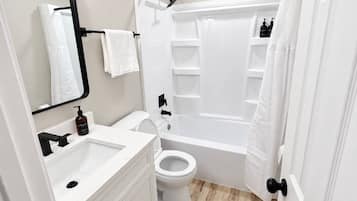 A modern bathroom with a white sink, toilet, and bathtub.
