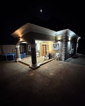 A house with a covered patio area, a pool, and a brick exterior. - Lyton CriB (Abeokuta)