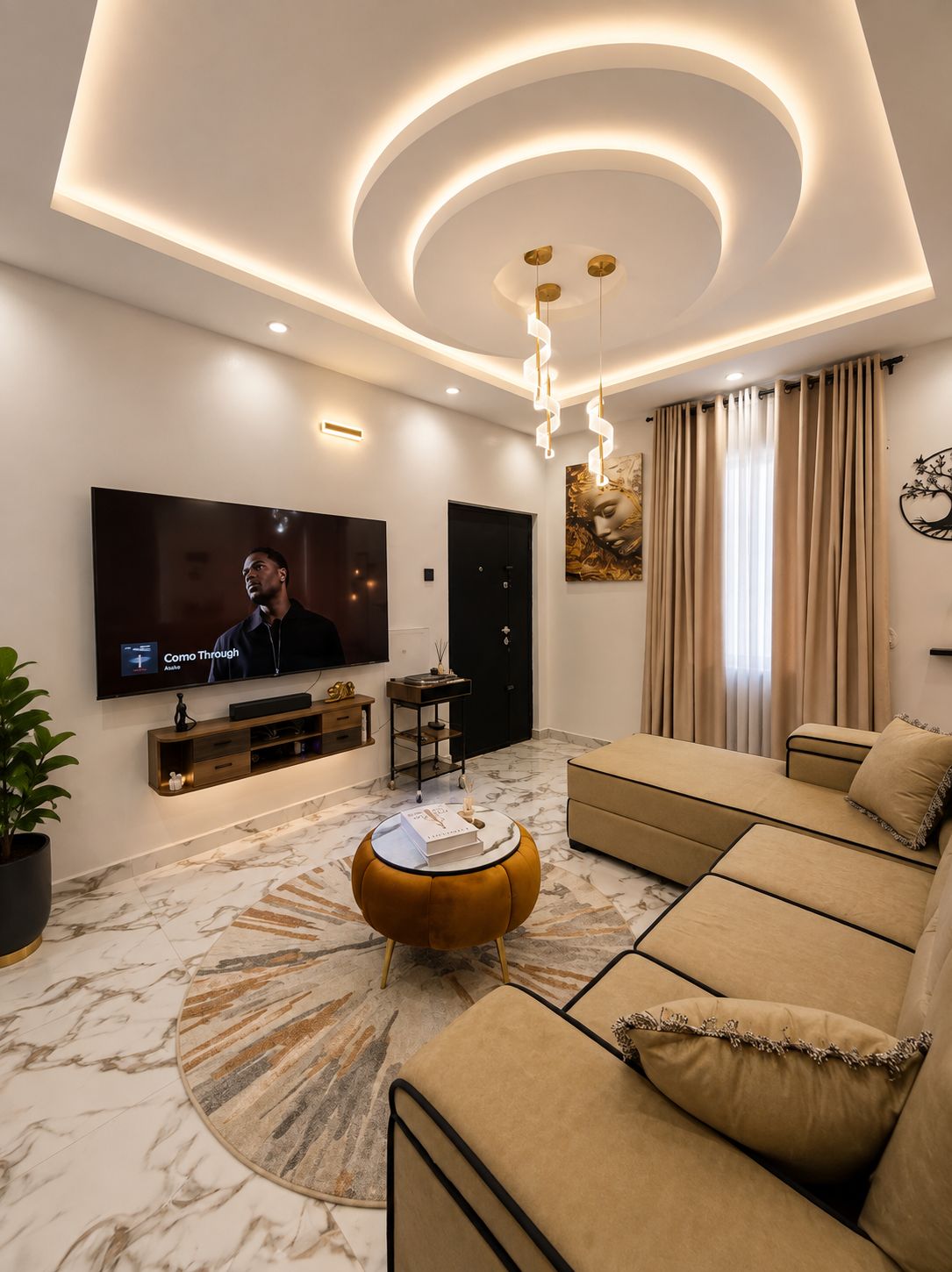A modern living room with a flat-screen TV, a sofa, a coffee table, and a patterned rug.