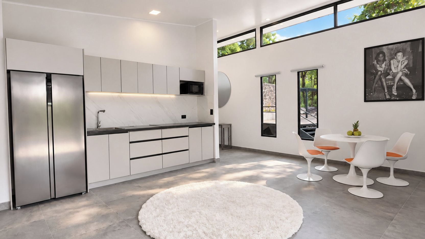 A modern kitchen with a built-in refrigerator, a microwave, and a dining area with a round table and chairs.