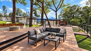 Una terraza moderna al aire libre con un sofá modular, una mesa de centro y un brasero.