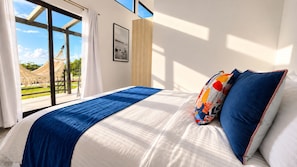 A hotel room with a large bed, a view of a garden, and a hammock outside the window. - Natura Lodge by Villa Alejandro (Bajo Boquete)