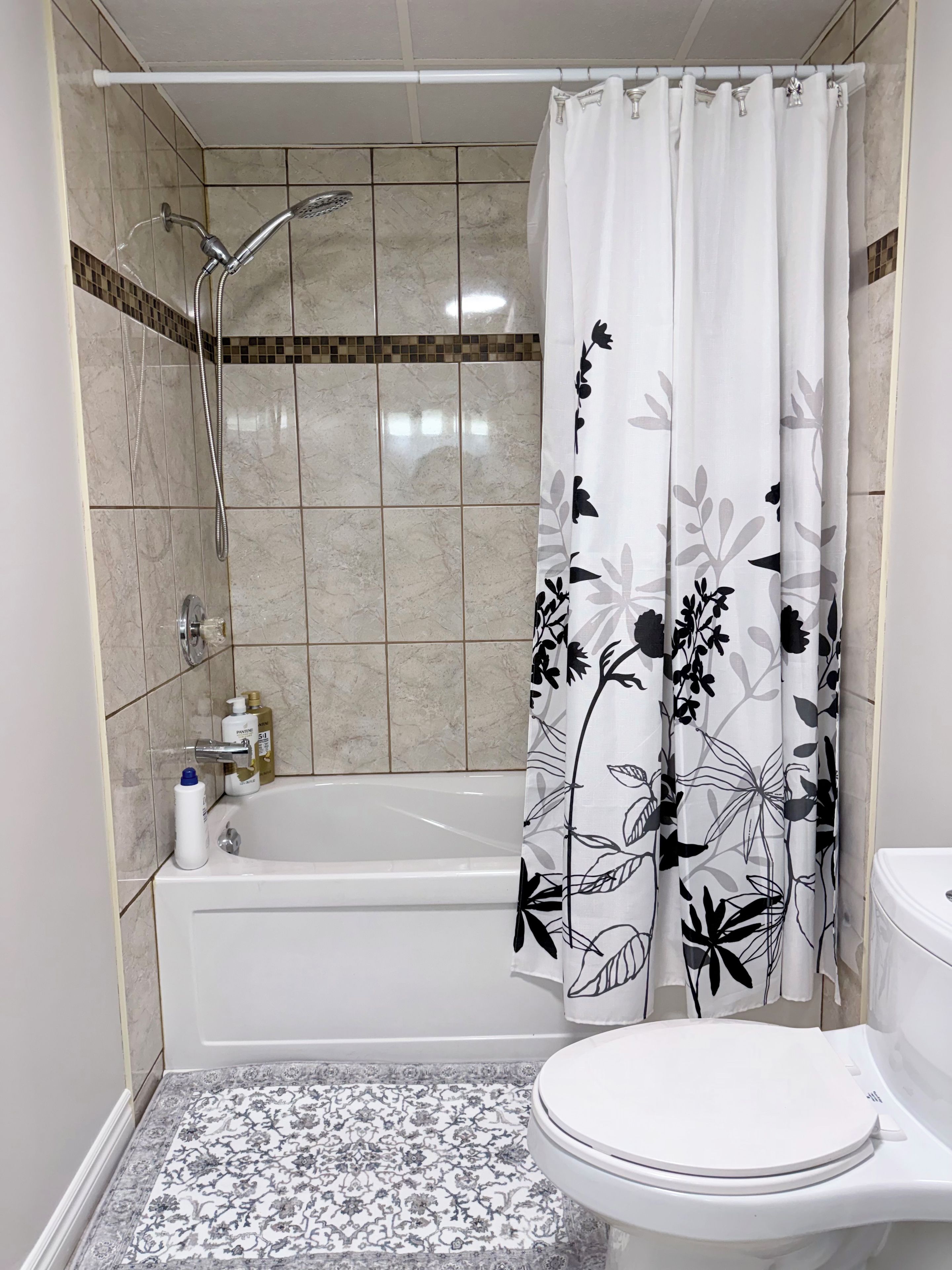 A bathroom with a bathtub, toilet, and shower area.