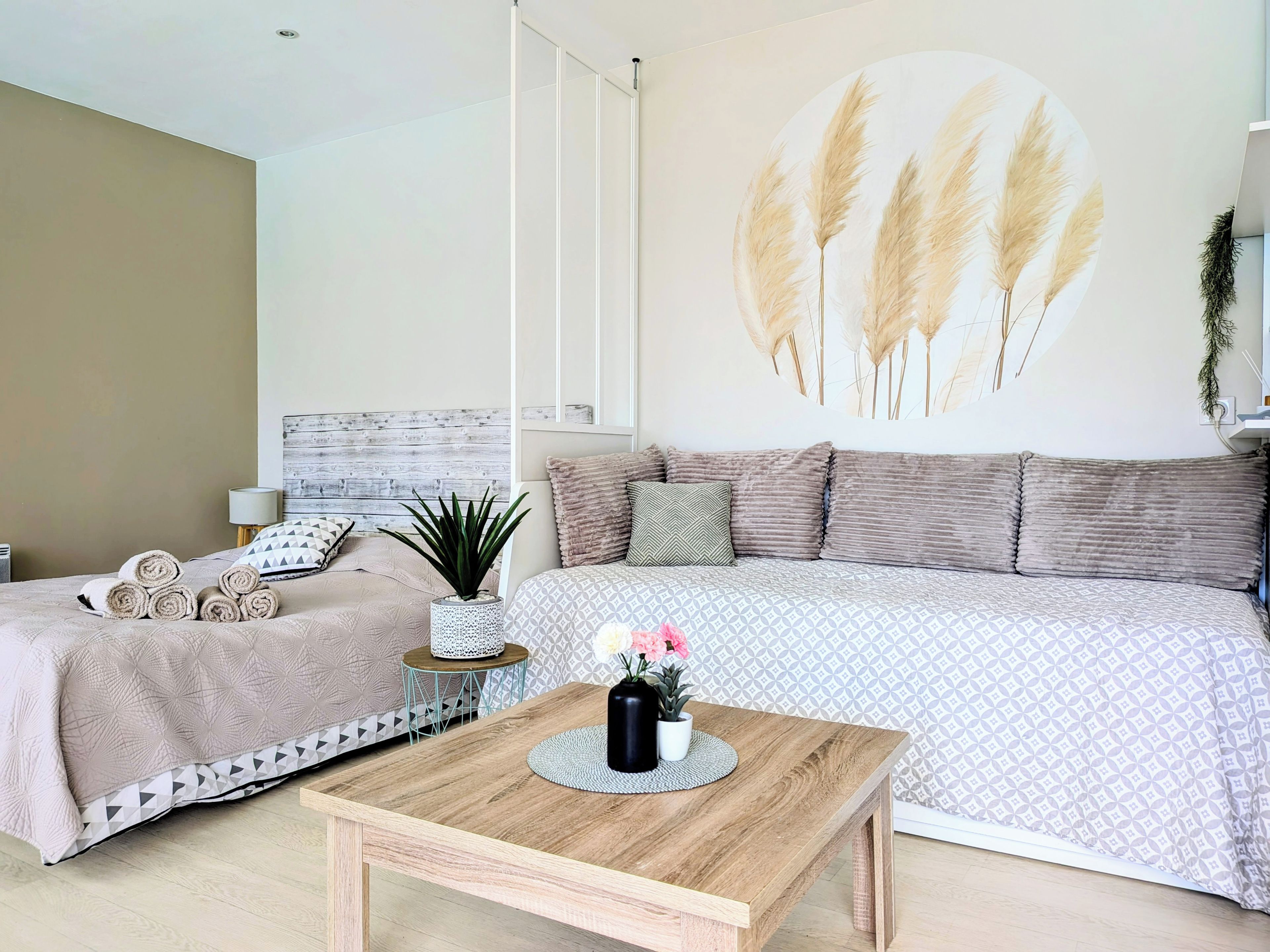 Une chambre moderne avec un lit, une table en bois et une œuvre d’art accrochée au mur.