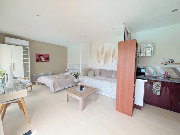 A modern living room with a sofa, a coffee table, and a dining area with a table and chairs.