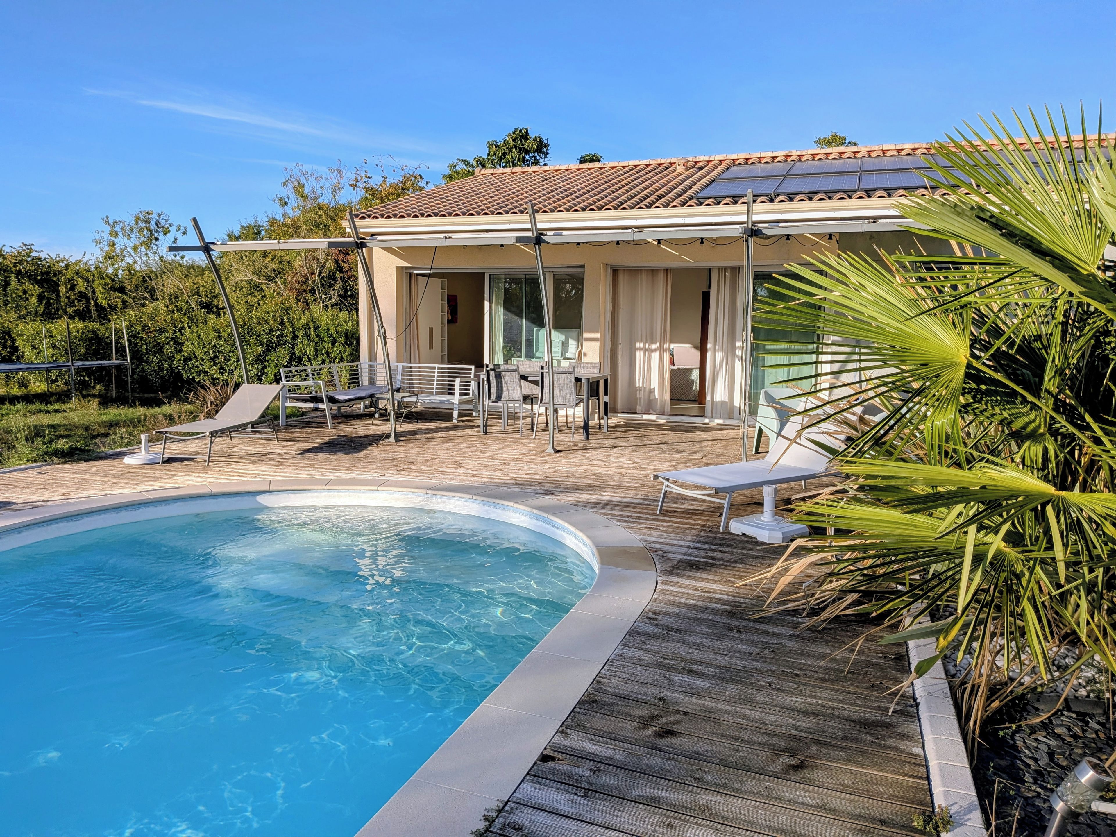 A swimming pool with lounge chairs and a covered patio area.