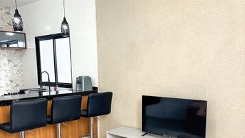Eine moderne Küche mit Barbereich, einem Flachbildfernseher und einem flauschigen Teppich.