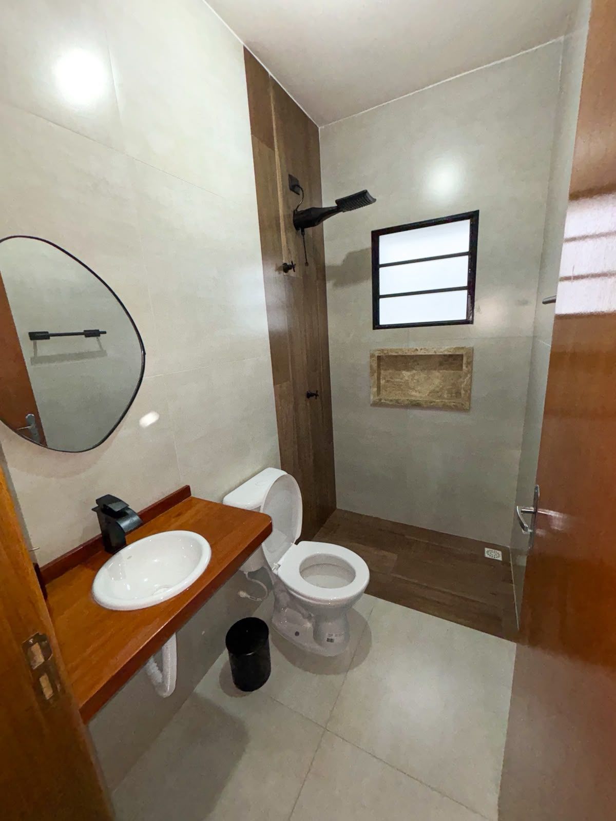 A compact bathroom with a toilet, sink, and mirror.