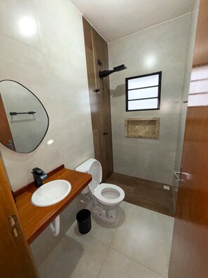 Ein kleines Badezimmer mit Toilette, Waschbecken und Spiegel.