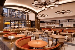 A modern restaurant with round tables and booths, a bar area, and a view through large windows. - Dreamy 1BR | Skyline Balcony City Views+ Pool, Spa, Gym (Miami)