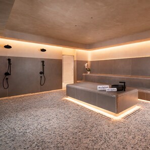 A modern bathroom with a freestanding bathtub, a vanity with a mirror, and two showerheads. - Dreamy 1BR | Skyline Balcony City Views+ Pool, Spa, Gym (Miami)