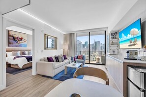 A modern hotel room with a city view, a dining area, and a kitchenette. - Dreamy 1BR | Skyline Balcony City Views+ Pool, Spa, Gym (Miami)