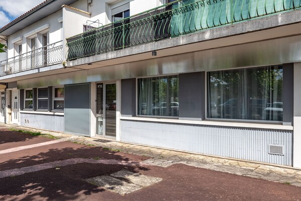 A two-story building with a balcony, large windows, and a door marked 'N°12'. - Vrbo Property (Montpon-Ménestérol)