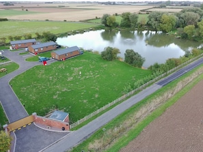 Zona residencial com lago, casas e rua pavimentada.