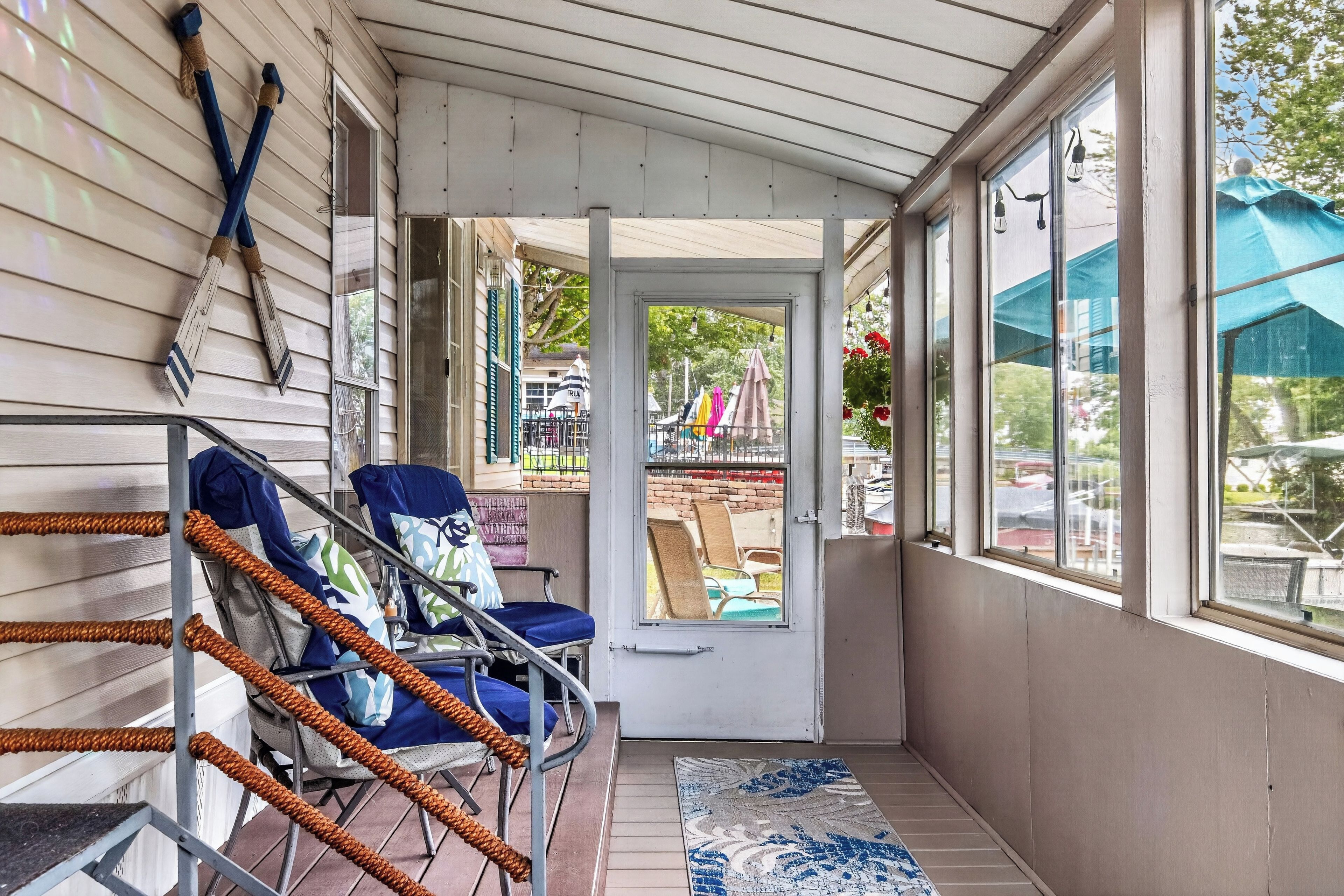 A covered porch with chairs and a view of the street.