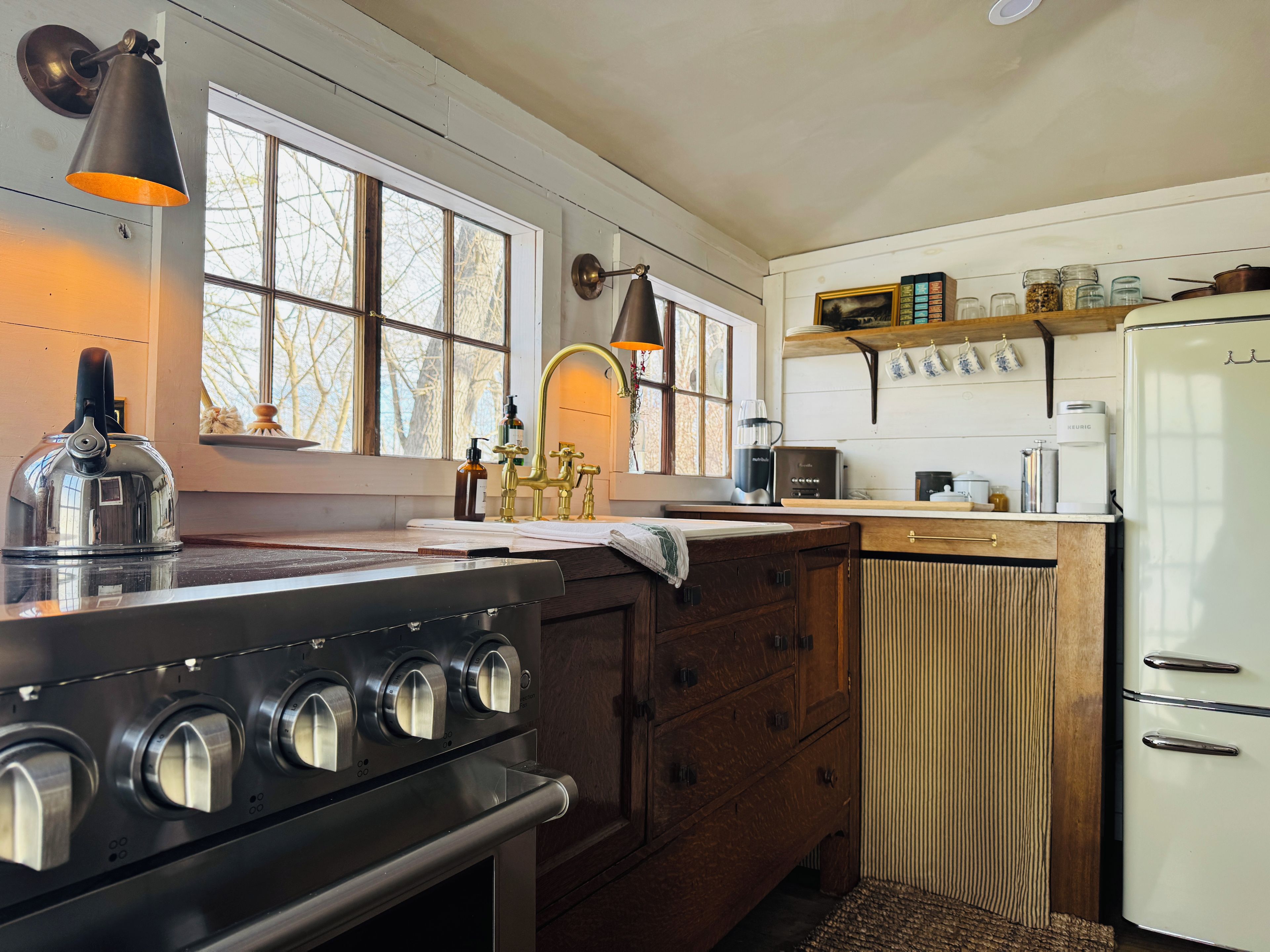 A kitchen with a stove, sink, and refrigerator.