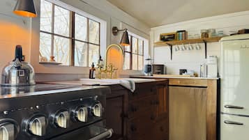 A kitchen with a stove, sink, and refrigerator.
