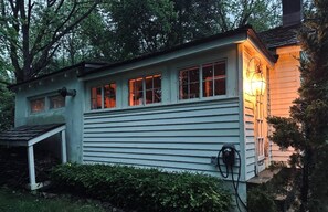 A single-story house with a garage, a porch, and a small attached shed.