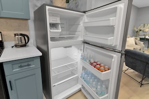 A kitchen with a built-in refrigerator, a coffee maker, and a sink.