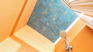 Un coin d’une salle de bain avec un pommeau de douche et un flexible de douche.