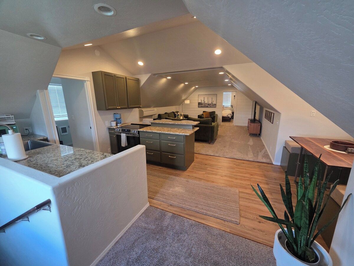Um espaço de estar tipo loft com cozinha, sala de jantar e área de estar.