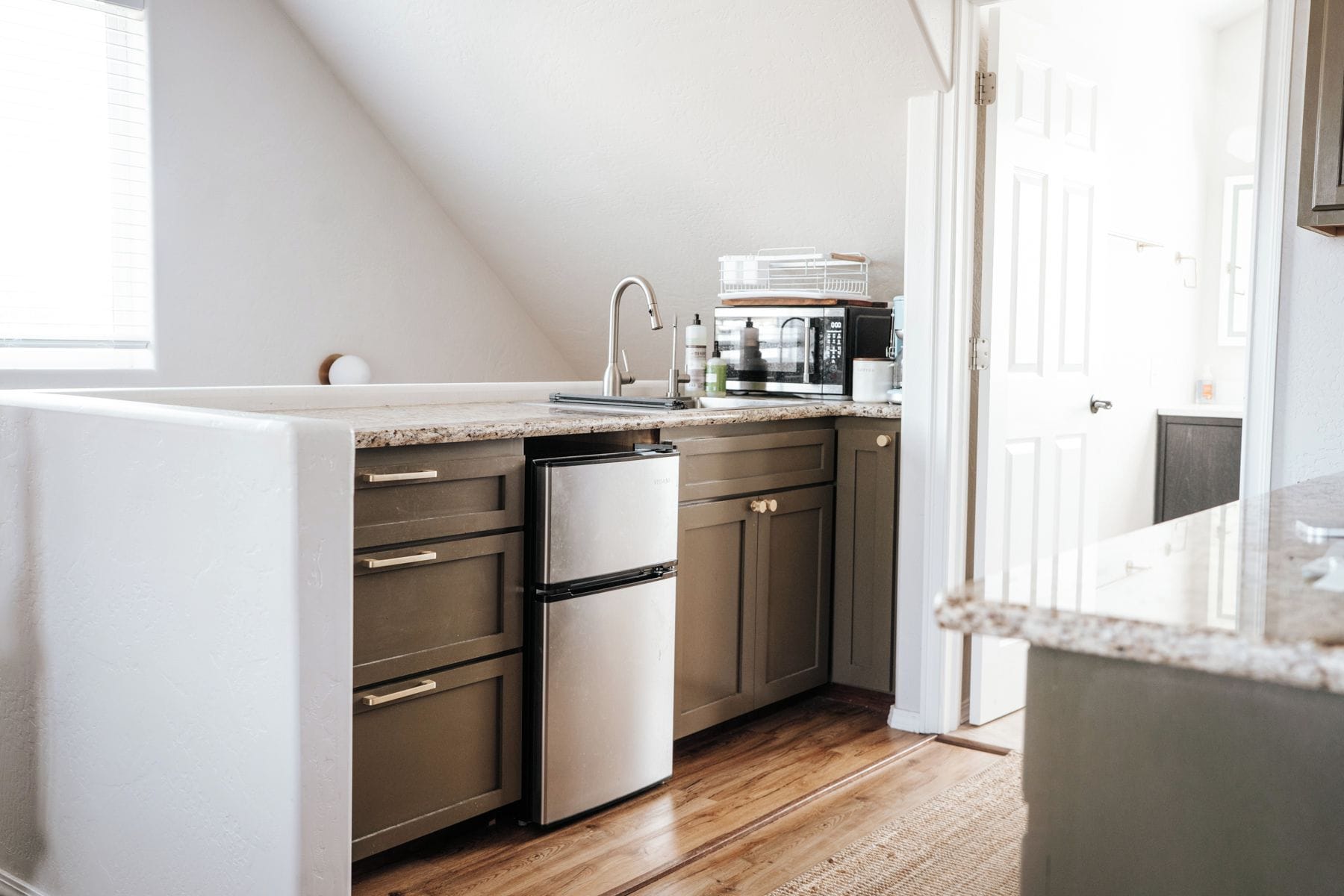 A kitchen with a dishwasher, microwave, and a sink.