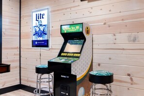 Ein 3D-Golf-Arcade-Spielgerät mit zwei Hockern davor.