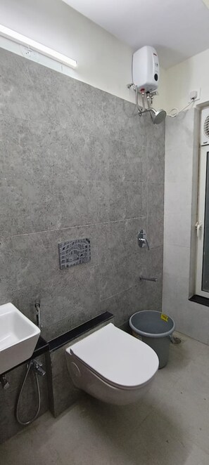 A bathroom with a shower, a toilet, and a sink. - Private Apartment With Metro View on Highway (Mumbai)
