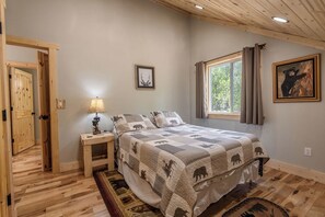 Una camera da letto con un letto, un comodino, una lampada, una finestra con tende e una porta.