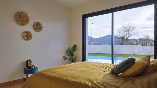 Ein Schlafzimmer mit einem Bett, einem großen Fenster und Wanddekorationen.