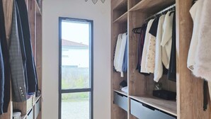 Ein begehbarer Kleiderschrank mit Holzböden und einem großen Fenster.