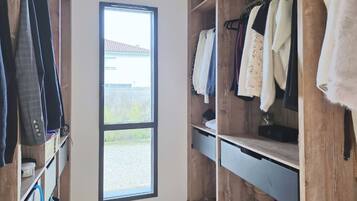 Een inloopkast met houten planken en een groot raam.
