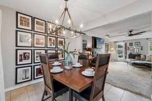 A dining area with a wooden table, chairs, and a chandelier. - Charming 3-bedroom house in adorable Edmond with quick access to I-35 or US-77 (Edmond)