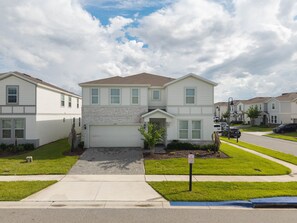 A two-story residential building with a garage, a driveway, and a 'No Parking' sign. - 3029 Magical 10BR | Pool, Dino Slide & Games (Davenport)