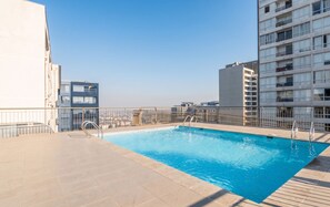 Una piscina en la azotea con vistas despejadas del horizonte urbano.