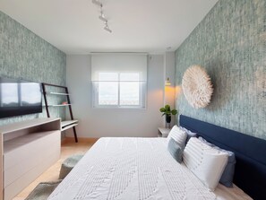 A bedroom with a bed, a TV, a desk, and a window. - Coastal Paradise 2BR Marina View (Rio Hato)