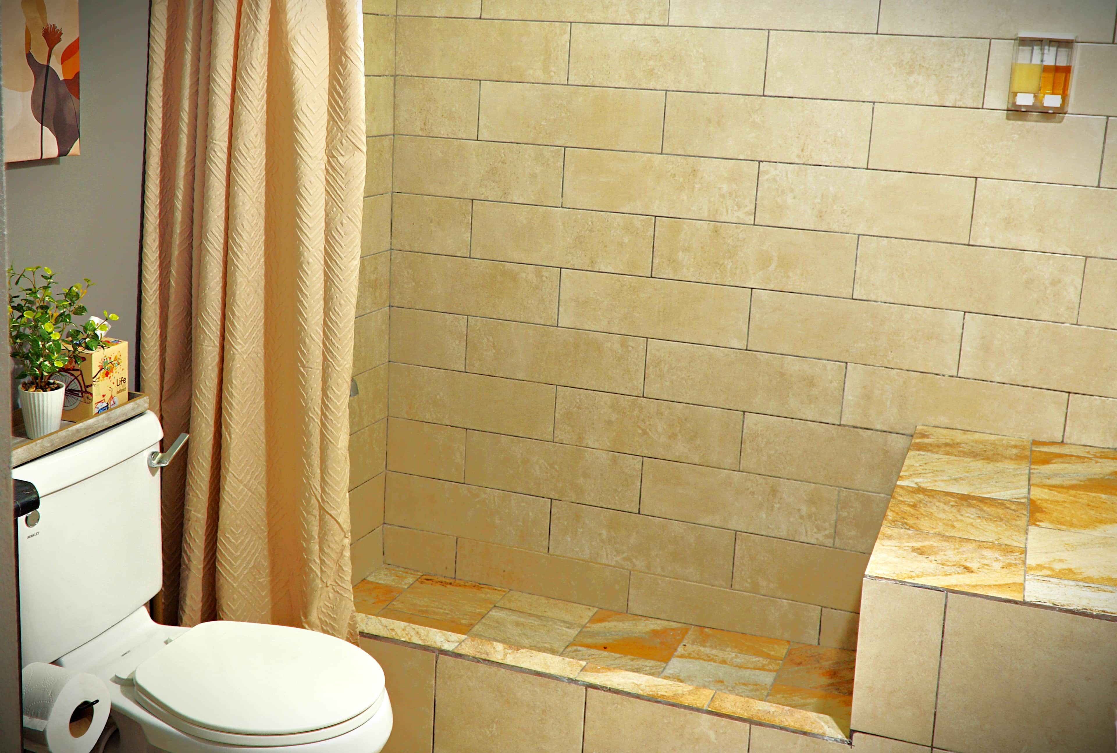 Une salle de bain équipée de toilettes, d’une douche et d’un porte-serviettes.