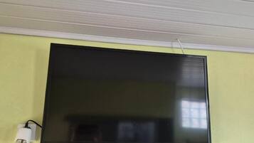 Televisor de pantalla plana montado en la pared con un cable de alimentación conectado.